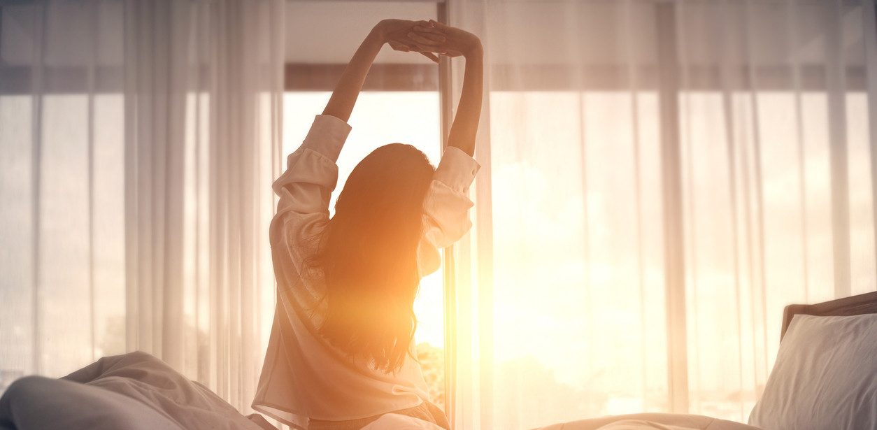 Woman stretching at sunrise
