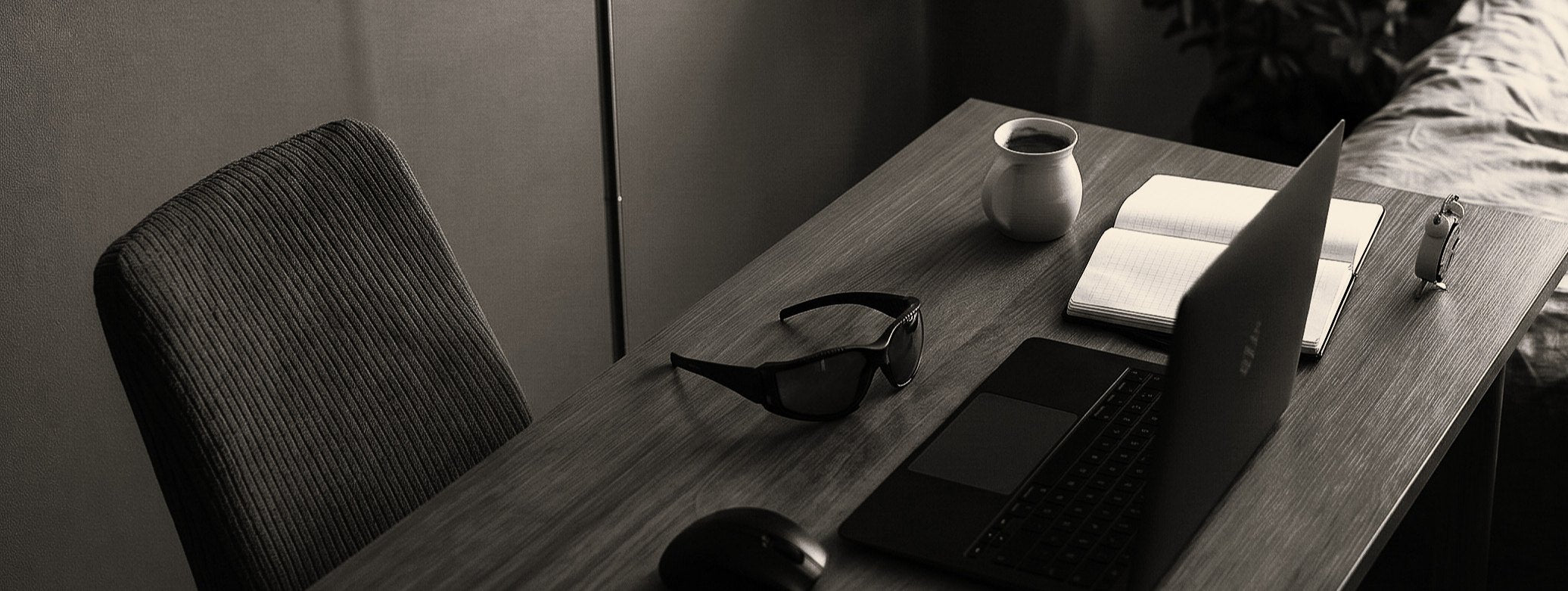 A dark desk at night with a laptop, notebook and Zeroblue glasses